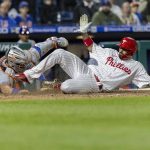 
              Philadelphia Phillies' Nick Castellanos, right, scores on an RBI double by Rhys Hoskins before New York Mets catcher James McCann (33) can make the tag during the eighth inning of a baseball game, Monday, April 11, 2022, in Philadelphia. (AP Photo/Laurence Kesterson)
            