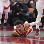 
              Atlanta Hawks guard Trae Young (11) looks toward the loose ball as he falls to the floor after being fouled by Toronto Raptors centre Khem Birch, right, during the second half of an NBA basketball game in Toronto on Tuesday, April 5, 2022. (Nathan Denette/The Canadian Press via AP)
            
