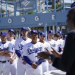 
              Los Angeles Dodgers players and staff listen to David Robinson, right, son of Jackie Robinson, speak before a baseball game between the Cincinnati Reds and the Los Angeles Dodgers in Los Angeles, Friday, April 15, 2022. Today MLB celebrates Jackie Robinson Day, in honor of Robinson, who was the first African American to play in the major leagues. (AP Photo/Ashley Landis)
            