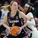 
              UConn's Paige Bueckers tries to get past South Carolina's Destanni Henderson during the first half of a college basketball game in the final round of the Women's Final Four NCAA tournament Sunday, April 3, 2022, in Minneapolis. (AP Photo/Charlie Neibergall)
            