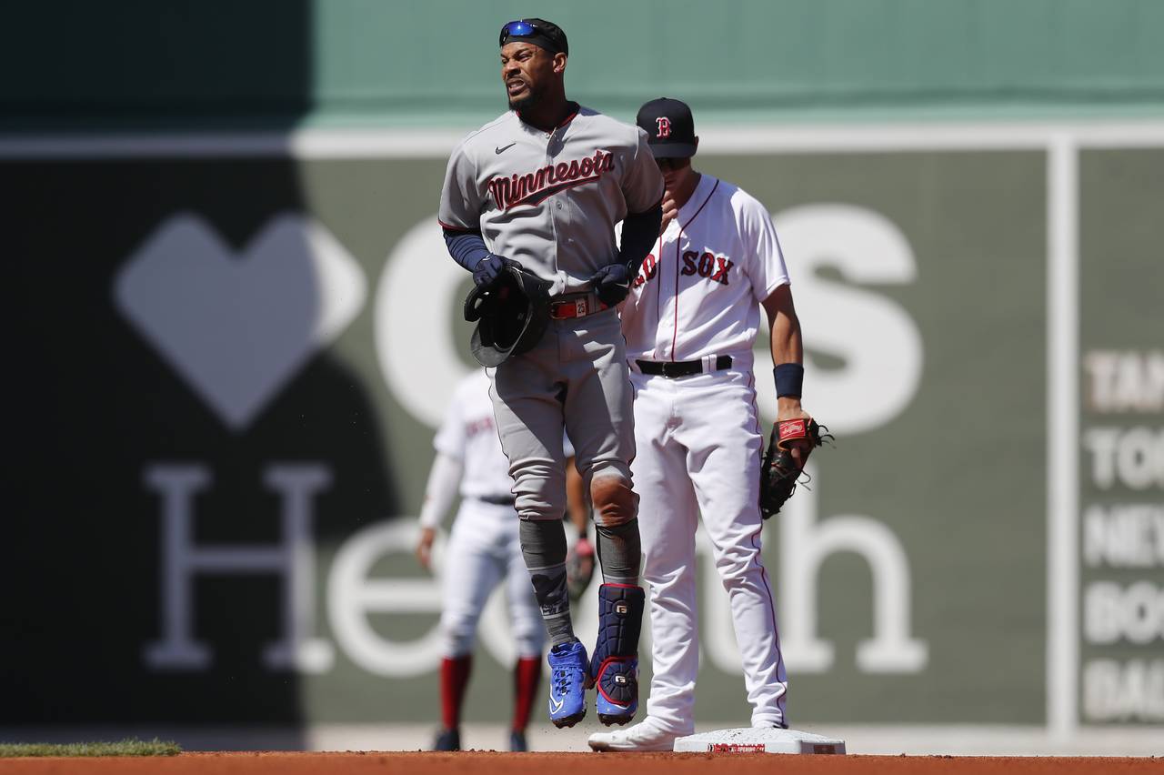 Minnesota Twins' Byron Buxton, front, reacts after being injured on his double during the first inn...