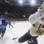 
              Vegas Golden Knights' Jack Eichel, right, trips and crashes into the boards while attempting to check Vancouver Canucks' J.T. Miller during the second period of an NHL hockey game in Vancouver, British Columbia, Sunday, April 3, 2022. (Darryl Dyck/The Canadian Press via AP)
            