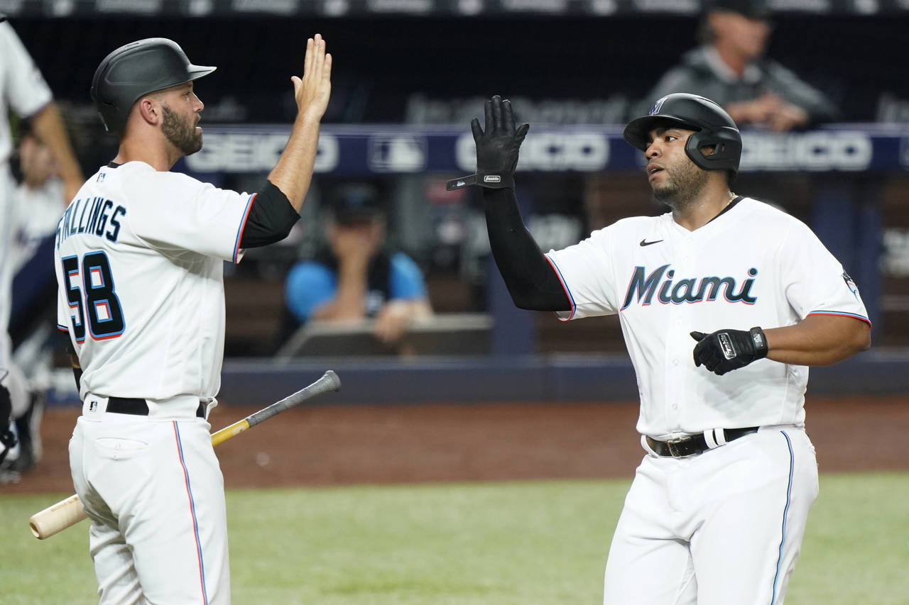 Miami Marlins' Jacob Stallings (58) and Jesus Aguilar congratulate each other after they both score...