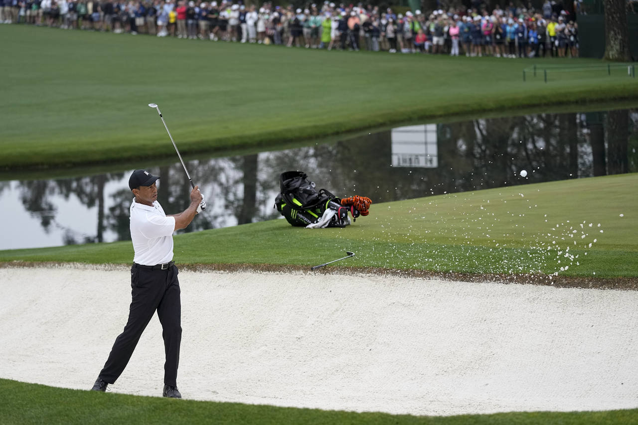 Tiger Woods hits out of a bunker on the 15th hole during a practice round for the Masters golf tour...