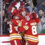 
              Calgary Flames left wing Matthew Tkachuk (19) celebrates his 40th goal and his 100th point of the season with teammates Johnny Gaudreau (13) and Andrew Mangiapane (88) during second-period NHL hockey game action against the Dallas Stars in Calgary, Alberta, Thursday April 21, 2022. (Larry MacDougal/The Canadian Press via AP)
            