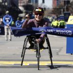 
              Manuela Schar, of Switzerland, hits the tape to win the women's wheelchair division of the 126th Boston Marathon, Monday, April 18, 2022, in Boston. (AP Photo/Winslow Townson)
            
