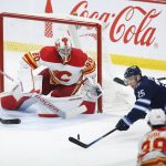 
              Winnipeg Jets' Paul Stastny (25) tries to get the shot away on Calgary Flames goaltender Dan Vladar (80) as Christopher Tanev (8) defends during the second period of an NHL hockey game Friday, April 29, 2022 in Winnipeg, Manitoba. (John Woods/The Canadian Press via AP)
            