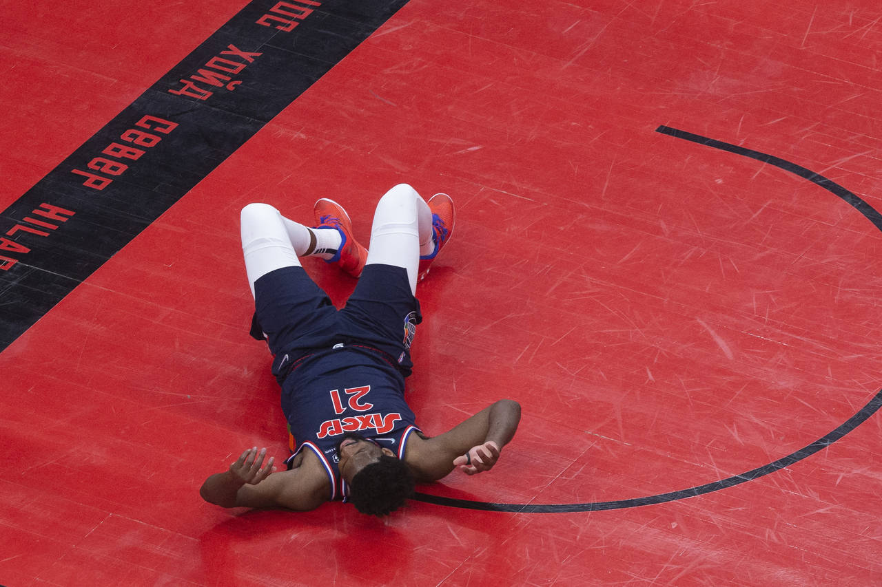 Philadelphia 76ers' Joel Embiid (21) lays down on the court after failing to score a shot during hi...
