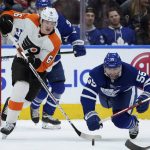 
              Philadelphia Flyers defenseman Travis Sanheim (6) and Toronto Maple Leafs defenseman Mark Giordano (55) battle for the puck during the second period of an NHL hockey game Tuesday, April 19, 2022 in Toronto. (Nathan Denette/The Canadian Press via AP)
            