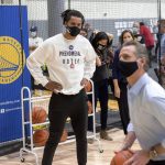 
              FILE - Golden State Warriors guard Damion Lee watches California Gov. Gavin Newsom shoot hoop during a visit to the team's training facility, which is serving as a polling location, on, Nov. 3, 2020, in Oakland, Calif. (AP Photo/Noah Berger, File)
            