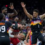 
              New Orleans Pelicans center Jonas Valanciunas, center, is pressured by Phoenix Suns guard Devin Booker (1), forward Jae Crowder (99) and center Deandre Ayton (22) during the second half of Game 1 of an NBA basketball first-round playoff series, Sunday, April 17, 2022, in Phoenix. (AP Photo/Matt York)
            