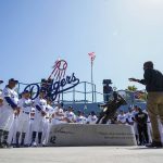 
              David Robinson, right front, son of Jackie Robinson, speaks to Los Angeles Dodgers players and staff while standing near a statue of his father, before a baseball game between the Cincinnati Reds and the Los Angeles Dodgers in Los Angeles, Friday, April 15, 2022. Today MLB celebrates Jackie Robinson Day, in honor of Robinson, who was the first African American to play in the major leagues. (AP Photo/Ashley Landis)
            