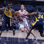 
              Detroit Pistons forward Kelly Olynyk (13) drives between Indiana Pacers forward Jalen Smith (25) and guard Buddy Hield (24) during the first half of an NBA basketball game in Indianapolis, Sunday, April 3, 2022. (AP Photo/Michael Conroy)
            