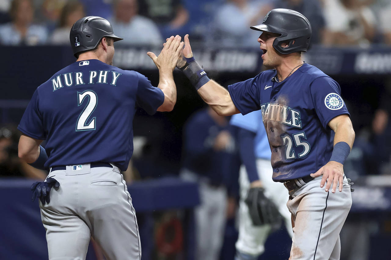 Seattle Mariners' Dylan Moore (25) celebrates with Tom Murphy as both score against the Tampa Bay R...