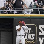 Chicago White Sox left fielder Eloy Jimenez catches a fly ball hit by Seattle Mariners right fielder Mitch Haniger during the first inning of an opening day baseball game in Chicago, Tuesday, April 12, 2022. (AP Photo/Nam Y. Huh)