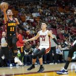 
              Atlanta Hawks guard Trae Young (11) goes to the basket as Miami Heat guard Tyler Herro (14) and center Dewayne Dedmon (21) watch during the first half of an NBA basketball game Friday, April 8, 2022, in Miami. (AP Photo/Lynne Sladky)
            
