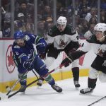 
              Vancouver Canucks' Conor Garland (8) vies for the puck against Arizona Coyotes' Barrett Hayton (29) as Janis Moser (62) watches during the first period of an NHL hockey game Thursday, April 14, 2022, in Vancouver, British Columbia. (Darryl Dyck/The Canadian Press via AP)
            