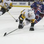 
              Pittsburgh Penguins defenseman Mike Matheson (5) and New York Rangers defenseman Adam Fox (23) chase the puck during the third period of an NHL hockey game Thursday, April 7, 2022, in New York. (AP Photo/Bebeto Matthews)
            