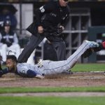 
              Seattle Mariners' J.P. Crawford scores on a Dylan Moore single as Chicago White Sox catcher Yasmani Grandal (24) applies a late tag during the fifth inning of a baseball game Wednesday, April 13, 2022, in Chicago. (AP Photo/Paul Beaty)
            