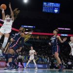 
              Stanford's Haley Jones shoots past UConn's Aaliyah Edwards during the second half of a college basketball game in the semifinal round of the Women's Final Four NCAA tournament Friday, April 1, 2022, in Minneapolis. UConn won 63-58 to advance to the finals. (AP Photo/Charlie Neibergall)
            