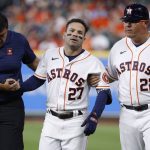 
              Houston Astros' Jose Altuve, center, is helped off the field after legging out an infield single in the bottom of the eighth inning against the Los Angeles Angels, Monday, April 18, 2022, in Houston. (Kevin M. Cox/The Galveston County Daily News via AP)
            