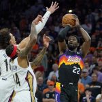 
              Phoenix Suns center Deandre Ayton (22) shoots over New Orleans Pelicans forward Brandon Ingram (14) during the first half of Game 5 of an NBA basketball first-round playoff series, Tuesday, April 26, 2022, in Phoenix. (AP Photo/Matt York)
            