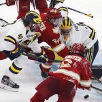 
              Denver's Carter Mazur (34) tries to get a shot on Michigan's Erik Portillo (1) during the second period of an NCAA men's Frozen Four semifinal hockey game, Thursday, April 7, 2022, in Boston. (AP Photo/Michael Dwyer)
            