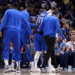 
              Dallas Mavericks guard Luka Doncic is helped off the court by teammates and a member of the staff after suffering an unknown lower leg injury in the second half of an NBA basketball game against the San Antonio Spurs, Sunday, April 10, 2022, in Dallas. (AP Photo/Tony Gutierrez)
            