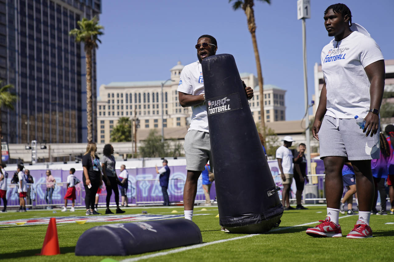 Kayvon Thibodeaux, left, participates in a community event ahead of the NFL draft Wednesday, April ...