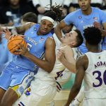 
              Kansas forward Mitch Lightfoot, right, draws the foul against North Carolina forward Armando Bacot (5) during the second half of a college basketball game in the finals of the Men's Final Four NCAA tournament, Monday, April 4, 2022, in New Orleans. (AP Photo/Gerald Herbert)
            