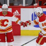 
              Calgary Flames left wing Johnny Gaudreau (13) is congratulated by center Elias Lindholm (28) after scoring an empty-net against the Chicago Blackhawks during the third period of an NHL hockey game, Monday, April 18, 2022, in Chicago. (AP Photo/Kamil Krzaczynski)
            