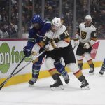 
              Vancouver Canucks' Luke Schenn (2) and Vegas Golden Knights' Nicolas Roy (10) vie for the puck during the second period of an NHL hockey game Tuesday, April 12, 2022, in Vancouver, British Columbia. (Darryl Dyck/The Canadian Press via AP)
            