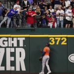 
              Houston Astros' Yordan Alvarez (44) watches as fans reach for a home run ball hit by Texas Rangers' Mitch Garver in the second inning of a baseball game, Wednesday, April 27, 2022, in Arlington, Texas. (AP Photo/Tony Gutierrez)
            