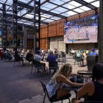 
              FILE - Fans watch the Milwaukee Bucks vs. Orlando Magic NBA playoff basketball game on a large TV at a bar across from the Fiserv Forum, Aug. 18, 2020, in Milwaukee. (AP Photo/Morry Gash)
            