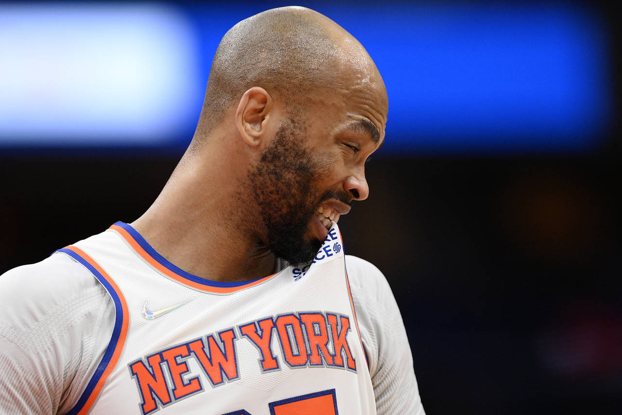 New York Knicks center Taj Gibson bites his jersey during the first half of the team's NBA basketba...