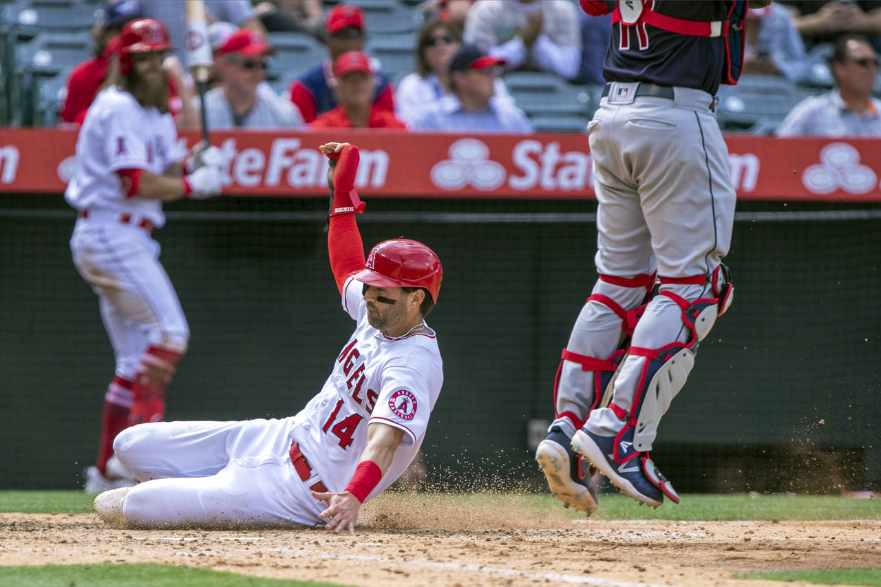 Los Angeles Angels' Tyler Wade scores next to Cleveland Guardians catcher Austin Hedges during the ...