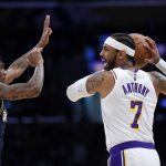 
              Los Angeles Lakers forward Carmelo Anthony, right, tries to pass while under pressure from Denver Nuggets guard Bones Hyland during the first half of an NBA basketball game Sunday, April 3, 2022, in Los Angeles. (AP Photo/Mark J. Terrill)
            