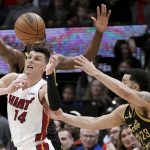 
              Miami Heat guard Tyler Herro (14) vies for a loose ball with Toronto Raptors' Fred VanVleet (23) and Precious Achiuwa (5) during the first half of an NBA basketball game Sunday, April 3, 2022, in Toronto. (Nathan Denette/The Canadian Press via AP)
            