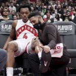 
              Toronto Raptors forward Scottie Barnes (4) has his injured ankle attended to on the bench during the first half of Game 4 of an NBA basketball first-round playoff series against the Philadelphia 76ers, Saturday, April 23, 2022 in Toronto. (Nathan Denette/The Canadian Press via AP)
            