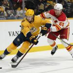
              Nashville Predators' Cody Glass (8) moves the puck ahead of Calgary Flames' Noah Hanifin (55) in the second period of an NHL hockey game Tuesday, April 19, 2022, in Nashville, Tenn. (AP Photo/Mark Humphrey)
            