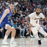
              Los Angeles Lakers guard D.J. Augustin, right, drives past Denver Nuggets forward Vlatko Cancar in the first half of an basketball game Sunday, April 10, 2022, in Denver. (AP Photo/David Zalubowski)
            