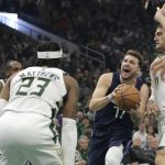 
              Dallas Mavericks' Luka Doncic (77) drives to the basket against Milwaukee Bucks' Brook Lopez, right, Wesley Matthews (23) and Khris Middleton, back left, during the first half of an NBA basketball game Sunday, April 3, 2022, in Milwaukee. (AP Photo/Aaron Gash)
            
