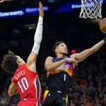 
              Phoenix Suns guard Devin Booker (1) drives as New Orleans Pelicans center Jaxson Hayes (10) defends during the first half of Game 1 of an NBA basketball first-round playoff series, Sunday, April 17, 2022, in Phoenix. (AP Photo/Matt York)
            