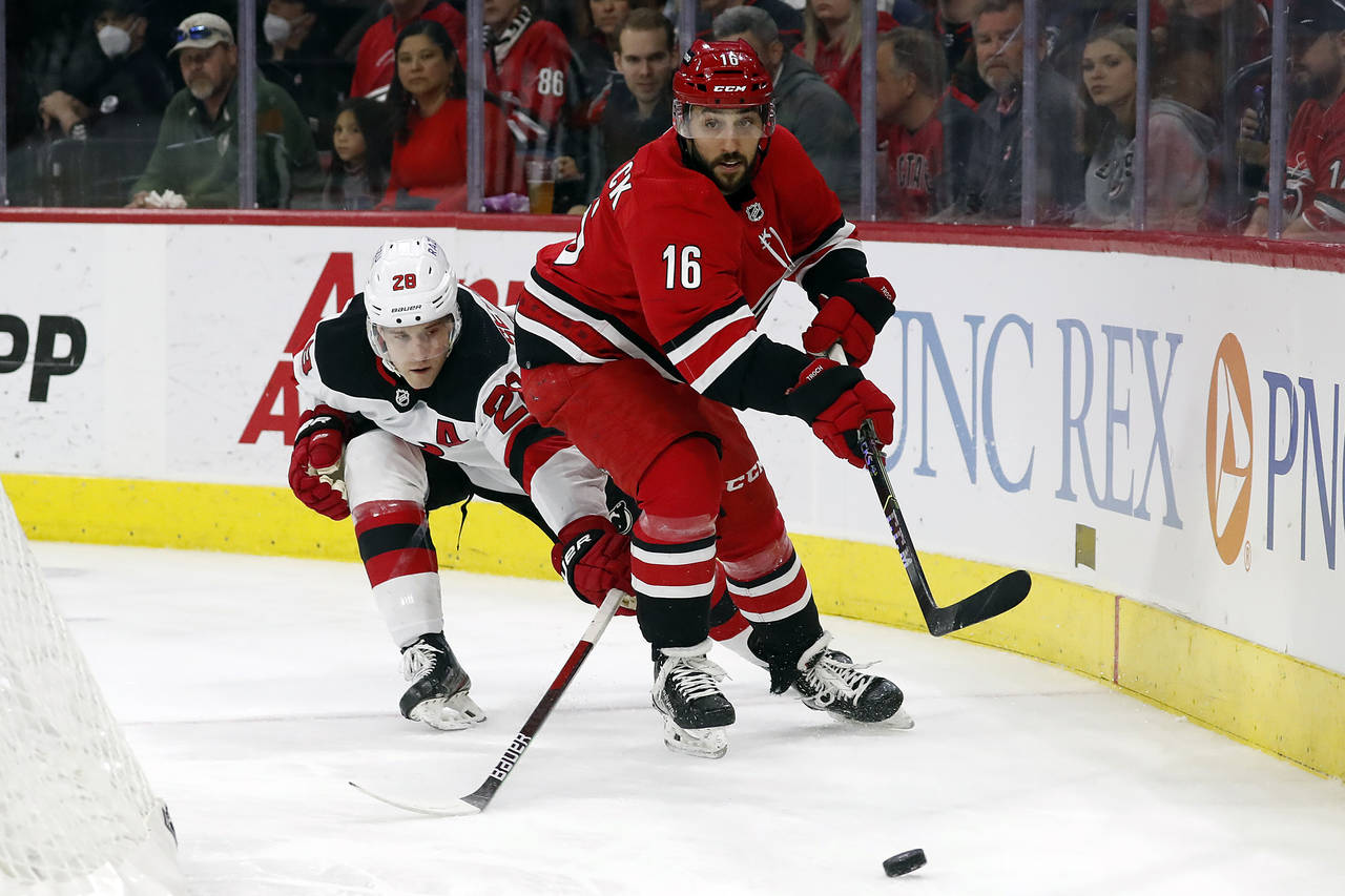 Carolina Hurricanes' Vincent Trocheck (16) clears the puck away from New Jersey Devils' Damon Sever...