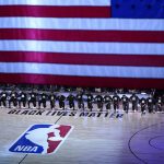 
              FILE - Members of the Orlando Magic and Brooklyn Nets kneel around a Black Lives Matter logo during the national anthem before the start of an NBA basketball game, in Lake Buena Vista, Fla., July 31, 2020. (AP Photo/Ashley Landis, Pool, File)
            