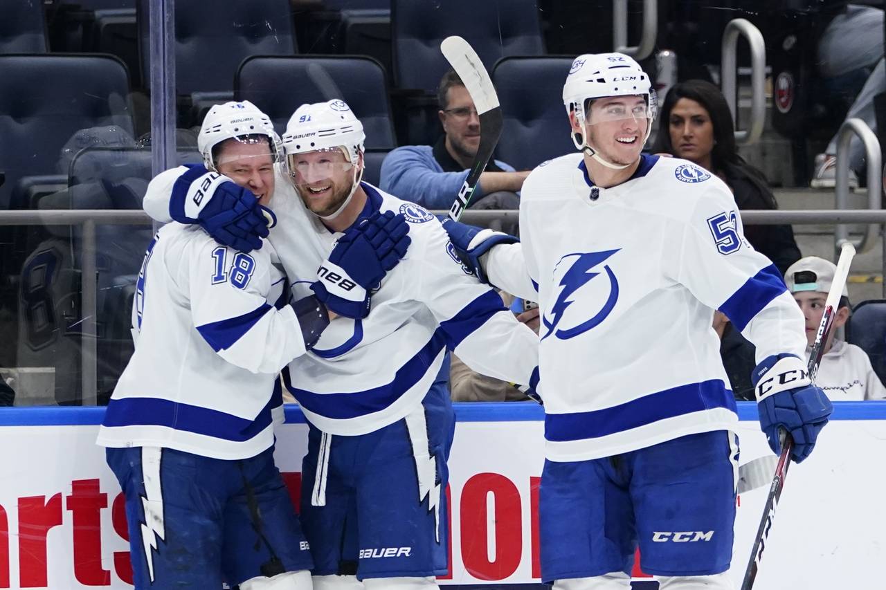 Steven Stamkos (91) celebrates with teammates Ondrej Palat (18) and Cal Foote (52) after scoring a ...