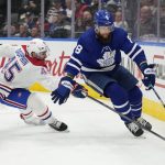 
              Toronto Maple Leafs defenseman Jake Muzzin (8) carries the puck from behind the net as Montreal Canadiens center Laurent Dauphin (45) gives chase during the first period of an NHL hockey game Saturday, April 9, 2022, in Toronto. (Frank Gunn/The Canadian Press via AP)
            