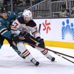
              San Jose Sharks left wing Rudolfs Balcers (92) and Edmonton Oilers defenseman Brett Kulak (27) vie for the puck during the first period of an NHL hockey game Tuesday, April 5, 2022, in San Jose, Calif. (AP Photo/Tony Avelar)
            