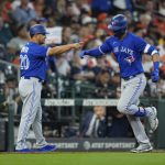 
              Toronto Blue Jays' Lourdes Gurriel Jr., right, celebrates with third base coach Luis Rivera (20) after hitting a home run against the Houston Astros during the fifth inning of a baseball game Sunday, April 24, 2022, in Houston. (AP Photo/David J. Phillip)
            