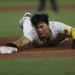 
              San Diego Padres' Ha-Seong Kim slides back to first base during the fifth inning of the team's baseball game against the Los Angeles Dodgers on Friday, April 22, 2022, in San Diego. (AP Photo/Mike McGinnis)
            